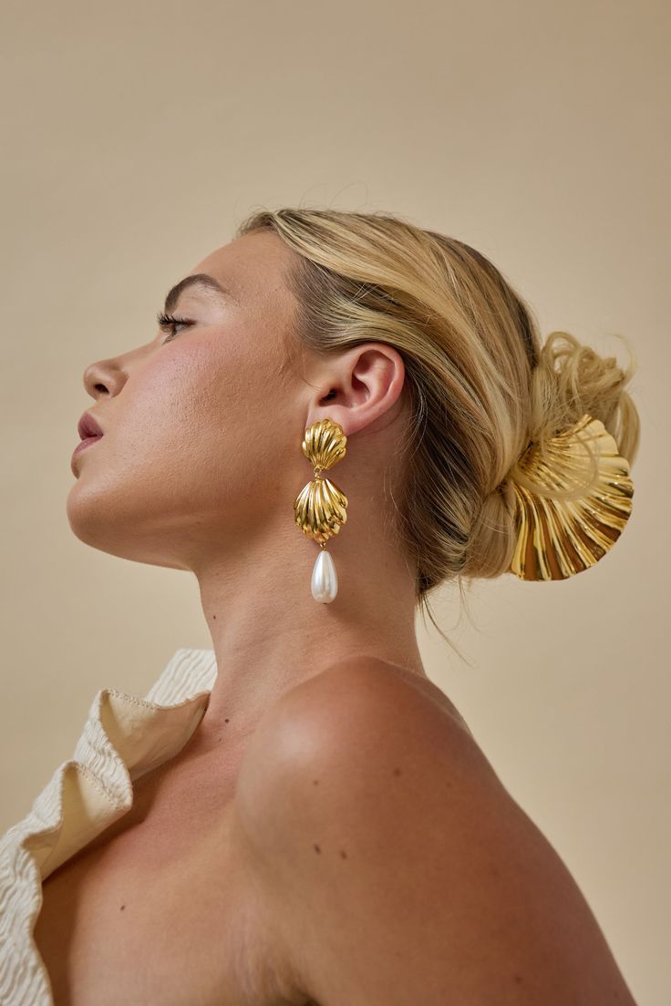 Channel your inner coastal goddess with our Serena Pearl Earrings. These stunning seashell drop earrings feature a teardrop pearl, adding a touch of elegance to your look. Hypoallergenic and carefully crafted, these earrings are both stylish and gentle on your skin. Elevate your style with these luxurious and exclusive earrings. Made in NYC. Luxury Accessories Aesthetic, Beach Inspired Jewelry, Soft Natural Jewelry, Pearl Earrings Aesthetic, Earring Photoshoot, Senior Dresses, Statement Bridal Jewelry, Statement Wedding Earrings, Lelet Ny