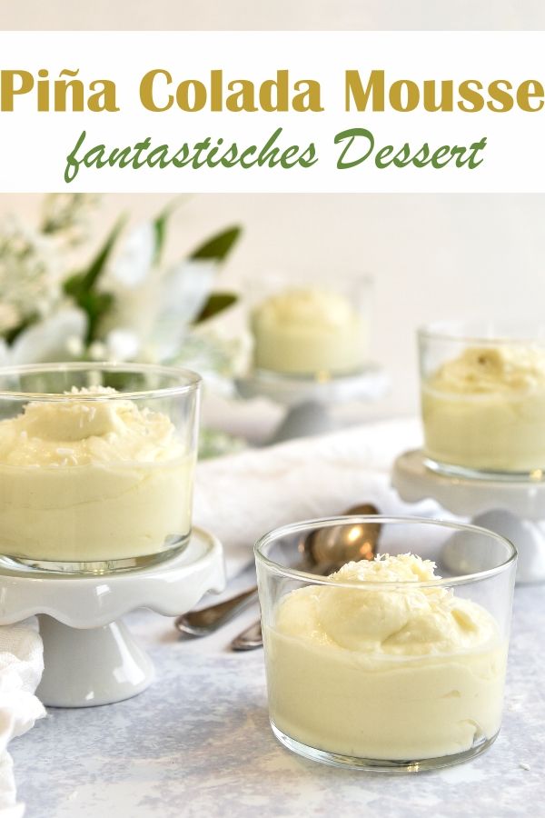 three small desserts with whipped cream in them on a white tablecloth and flowers