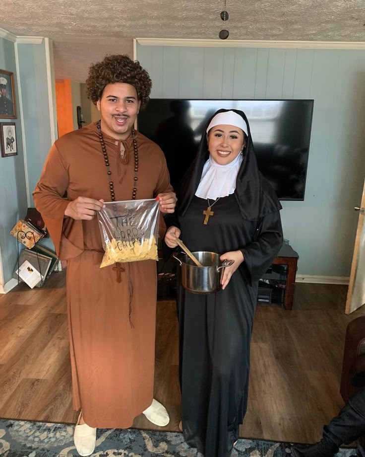 two people dressed as nun and nunette holding food in front of a television screen