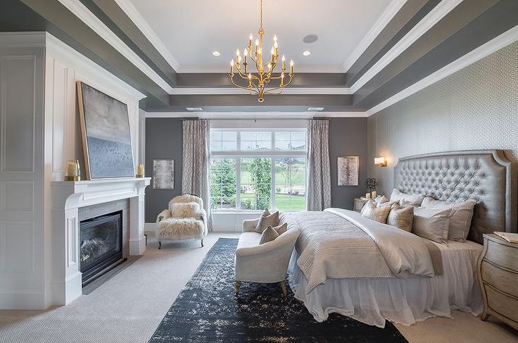 a large bedroom with a fireplace and chandelier