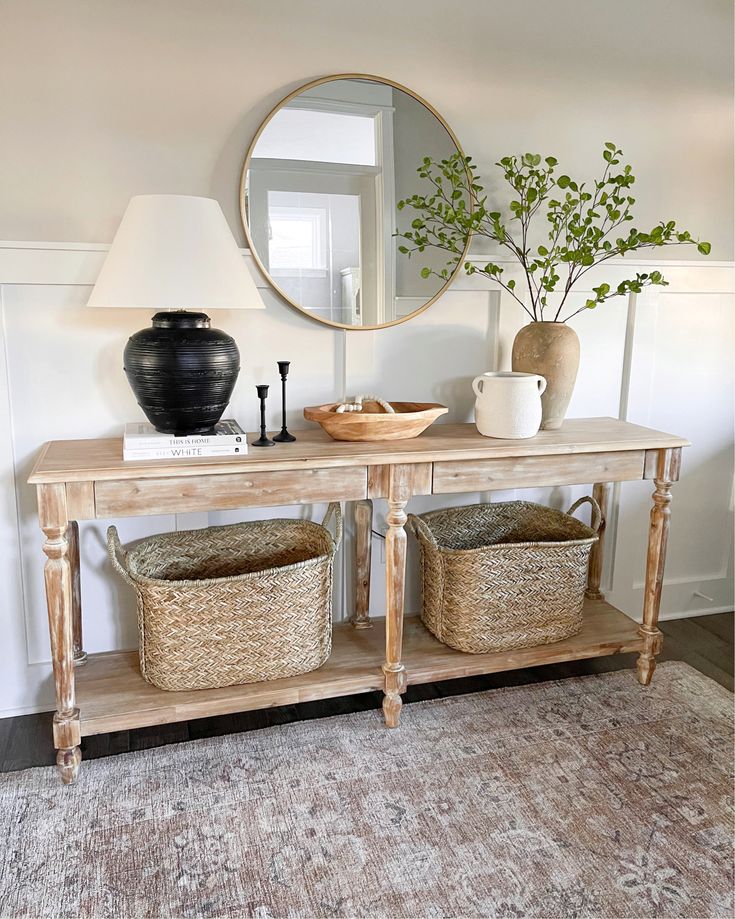 a wooden table with baskets under a mirror