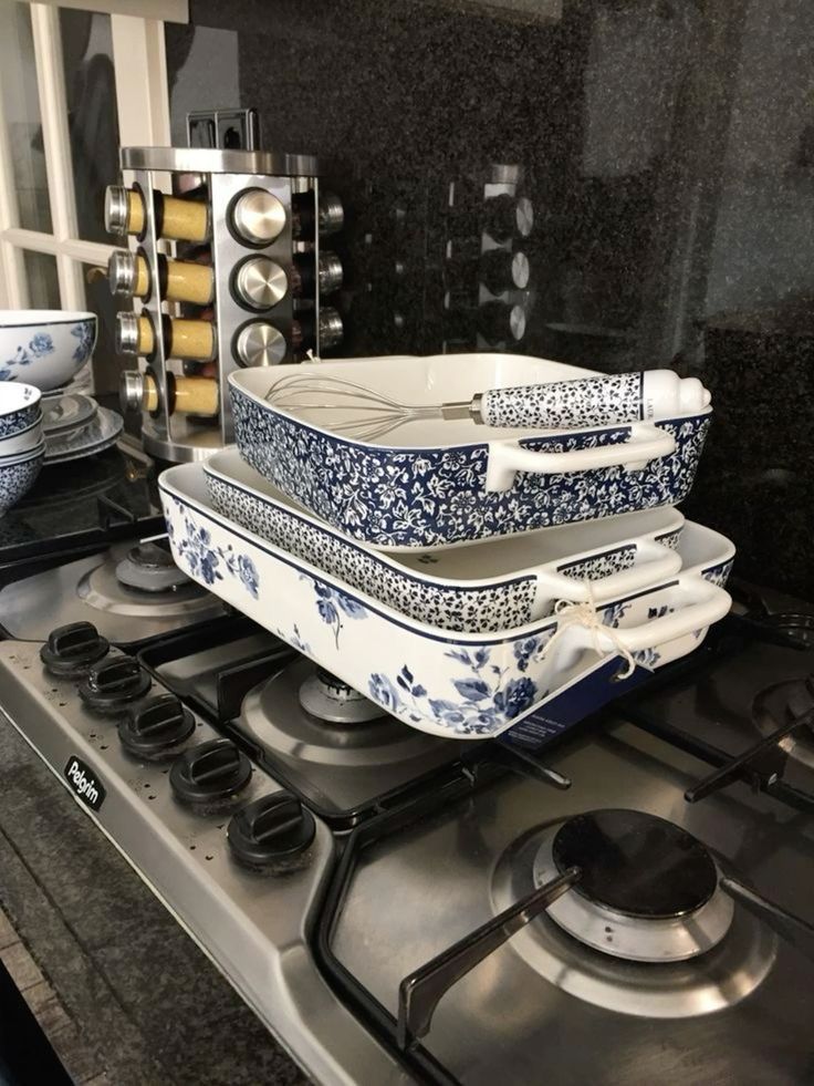 a stove top with dishes stacked on top of it