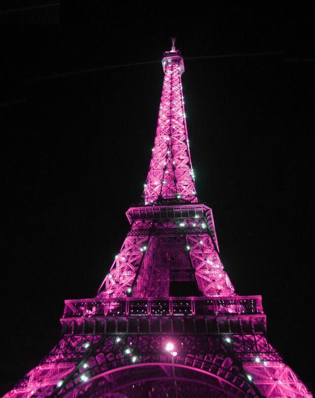 the eiffel tower is lit up in pink