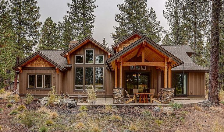 a large house in the woods with lots of windows