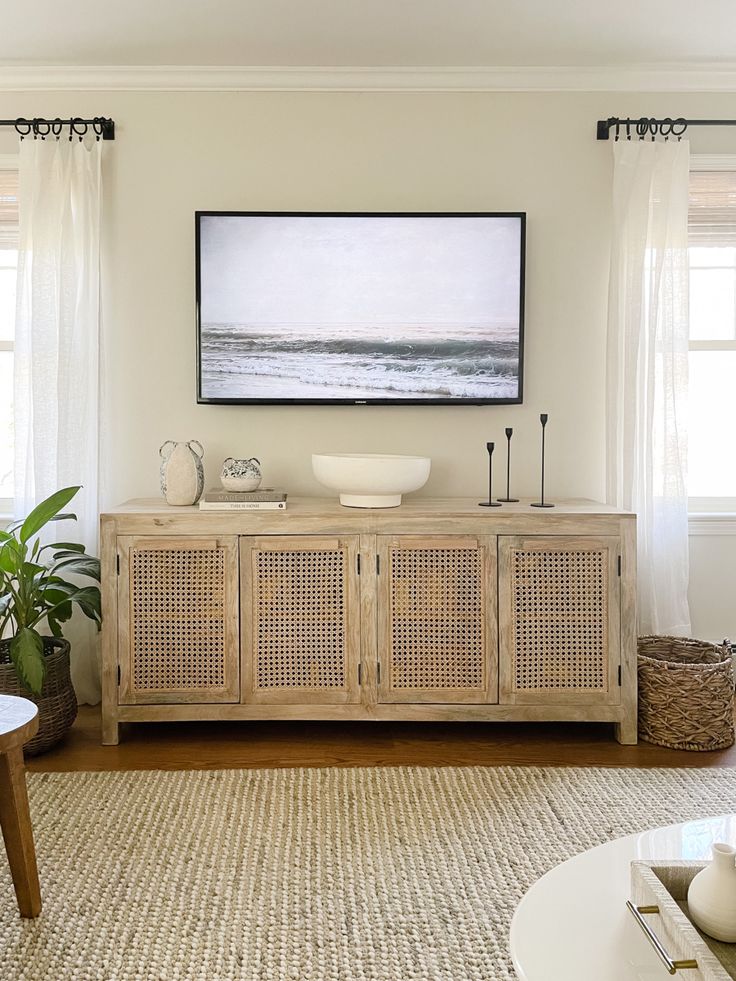 a living room filled with furniture and a painting hanging on the wall above it's windows