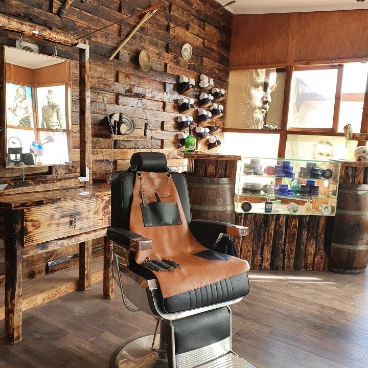 a barber chair sitting in front of a mirror on top of a hard wood floor