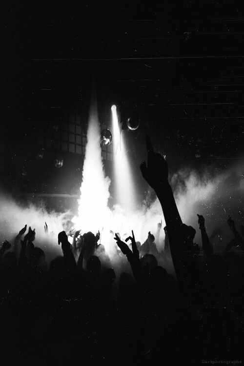 a group of people standing on top of a stage with their hands in the air