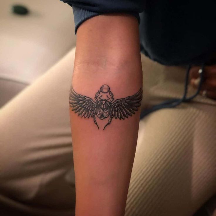 a woman's arm with a tattoo on it and an eagle in the middle