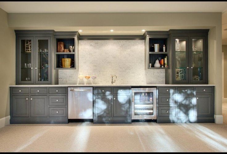 an empty kitchen with gray cabinets and stainless steel appliances