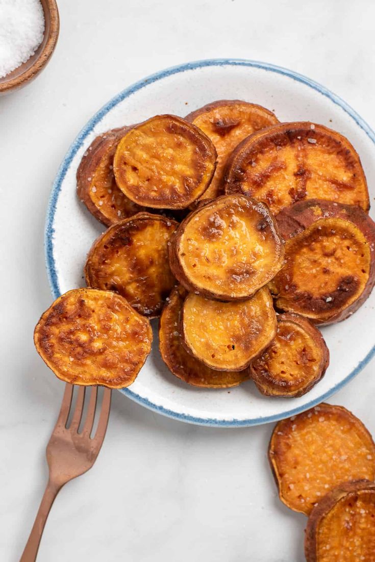 a white plate topped with sliced bananas on top of a table next to a fork