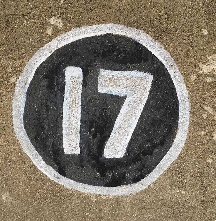 a black and white street sign with the number seventy on it's side in cement