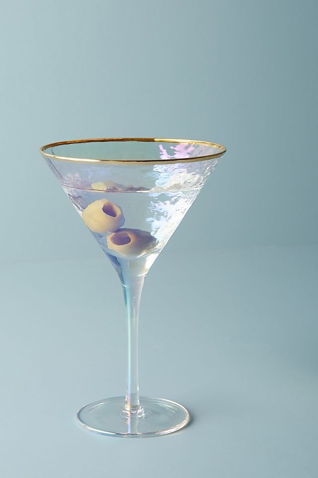 an empty martini glass with olives in it