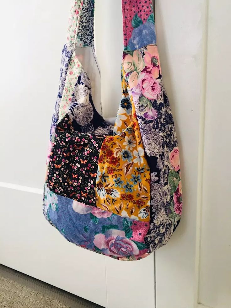 a multicolored purse hanging on a hook in front of a white door with flowers