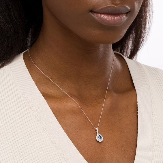 Increase the elegance factor of your dressy looks with this beautiful gemstone and diamond pendant. Fashioned in 14K white gold, this choice showcases a 6.0 x 4.0mm pear-shaped bright blue sapphire wrapped in a double frame of shimmering diamonds. Additional diamonds glisten along the linear bail to complete the design. Captivating with 3/8 ct. t.w. of diamonds and a brilliant buffed luster, this pendant suspends along an 18.0-inch rope chain that secures with a spring-ring clasp. Elegant Teardrop Pendant Birthstone Necklace For Anniversary, White Gold Birthstone Necklace In Fine Jewelry Style, Formal Birthstone Necklace With Diamond Cut, Elegant Jewelry With Halo Setting In Drop Shape, Elegant Polished Birthstone Necklace, Elegant Drop Jewelry With Halo Setting, Elegant Sapphire Necklace With Oval Pendant, Elegant Sapphire Oval Pendant Necklace, Elegant Sapphire Jewelry With Halo Setting