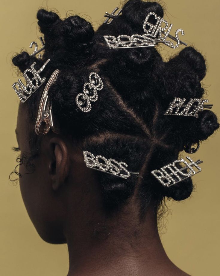 the back of a woman's head with hair clips in her hair and diamond - embellishments on it