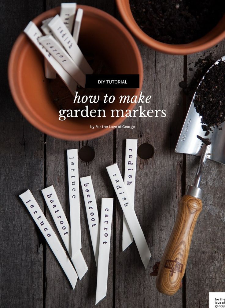 gardening markers are sitting on a table next to a potted plant and measuring tape