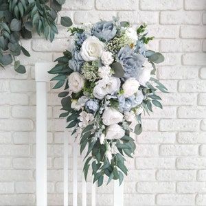 a bouquet of flowers on a chair against a brick wall