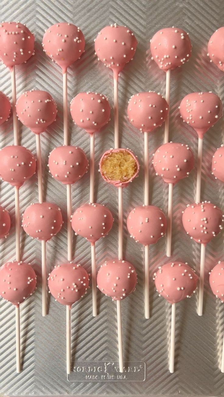 pink cake pops with white sprinkles on top