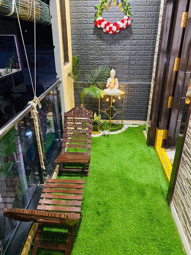 an indoor area with artificial grass and wooden benches