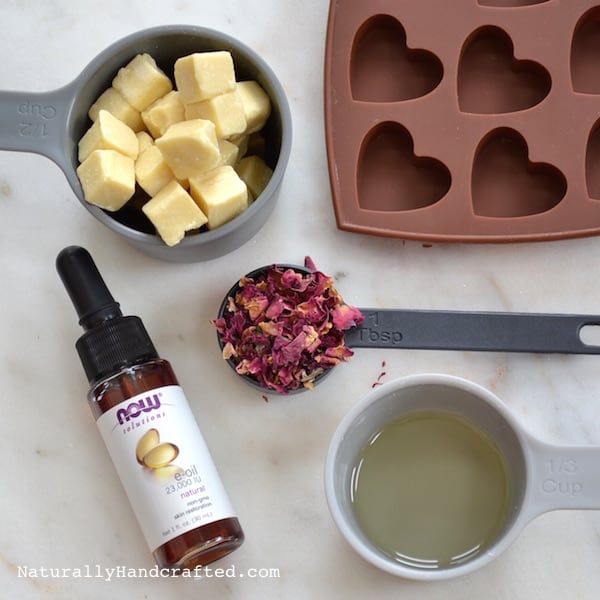 ingredients to make heart shaped cupcakes laid out on a white counter top with utensils