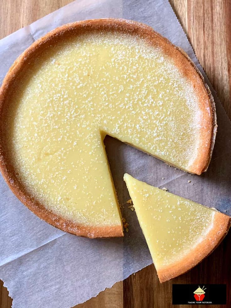 a cheesecake with one slice cut out on a piece of paper next to it