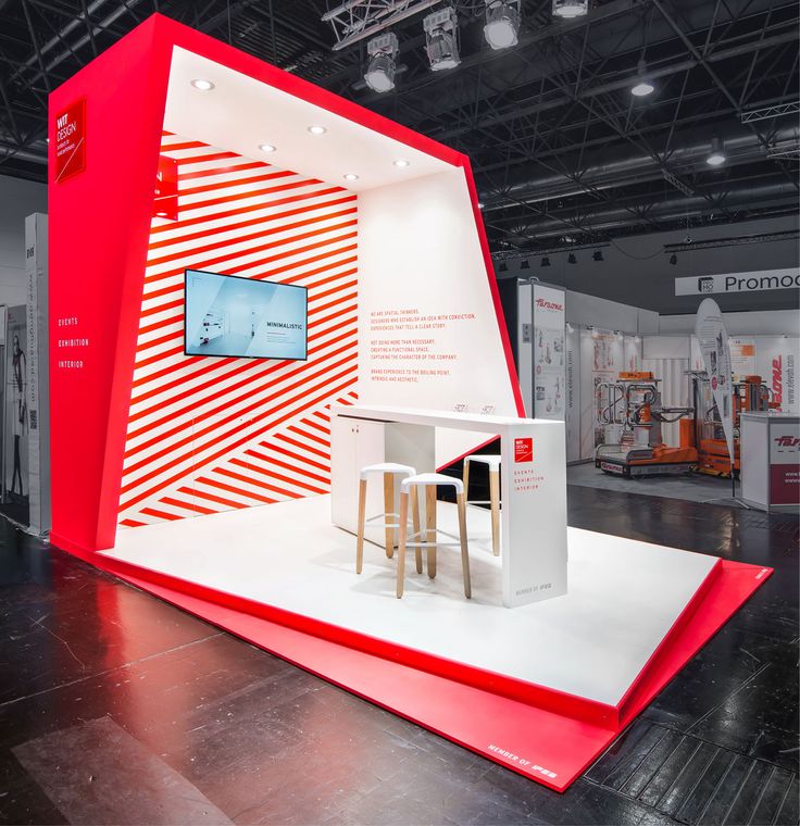 an exhibit display with red and white stripes on the wall, two stools in front of it