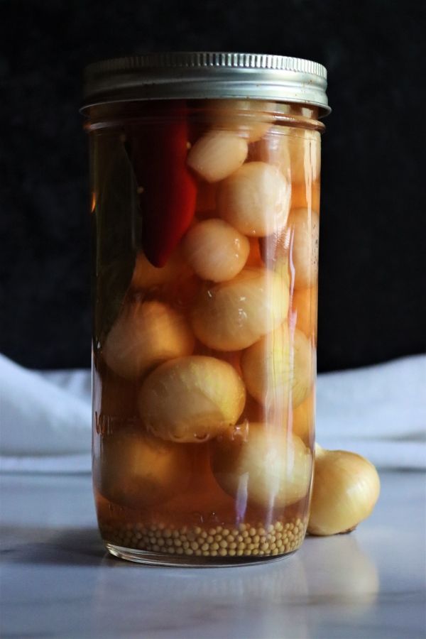 a jar filled with pickled onions on top of a table