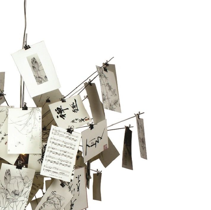 several pieces of art hanging from clothes pins with notes attached to them, all over the place