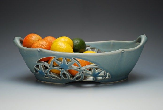 a bowl filled with oranges and limes on top of a table