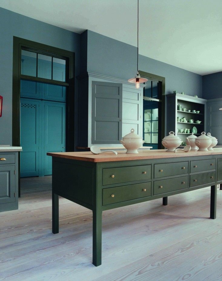 a kitchen with blue cabinets and wooden floors