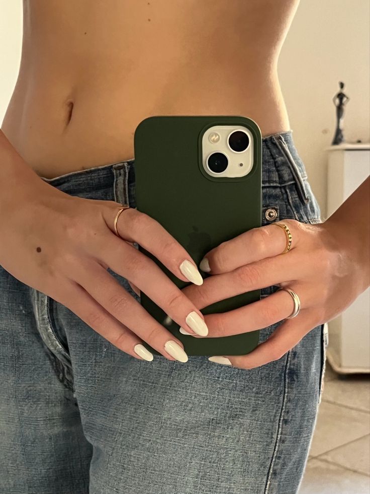 a woman is holding her phone in one hand and showing off her green iphone case