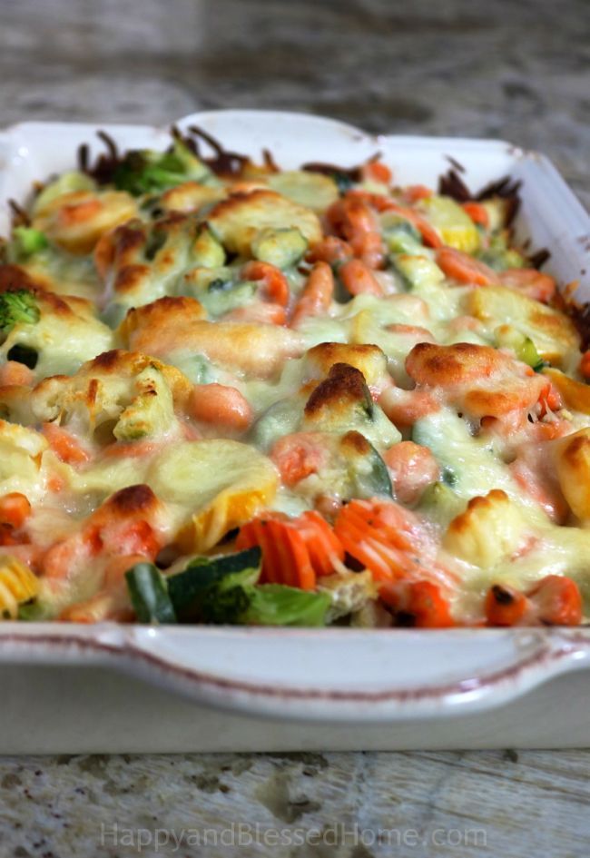 a casserole dish with broccoli, carrots and other vegetables in it