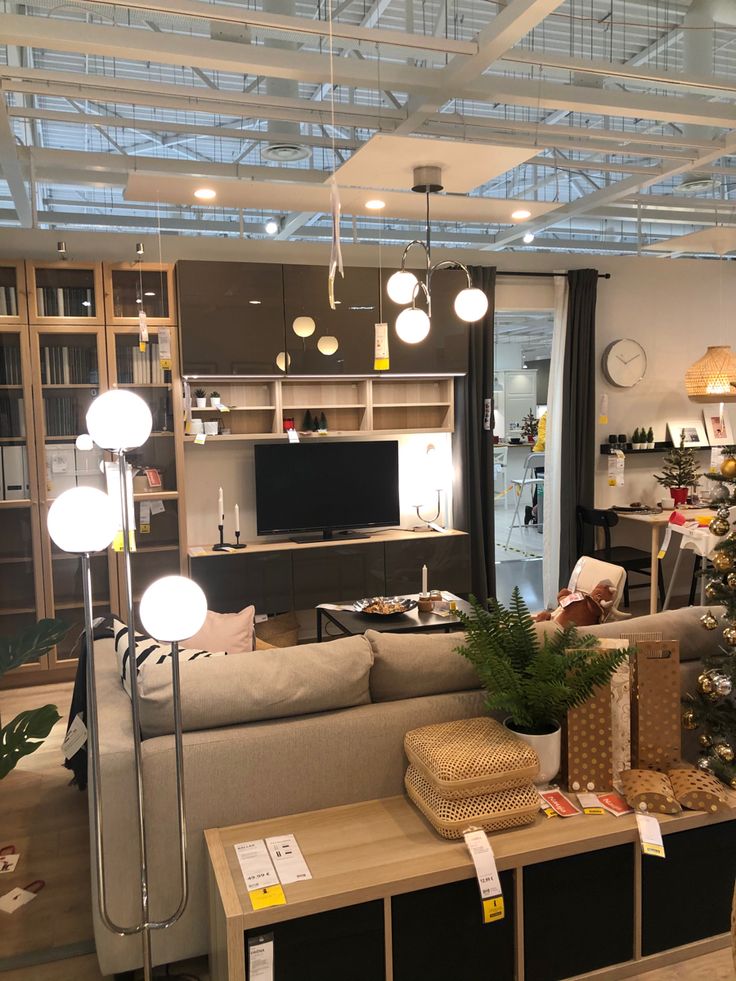 a living room filled with lots of furniture and christmas tree in the middle of it