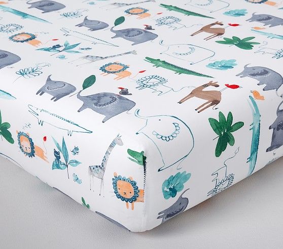 a baby crib sheet with animals and plants on it, in blue and green