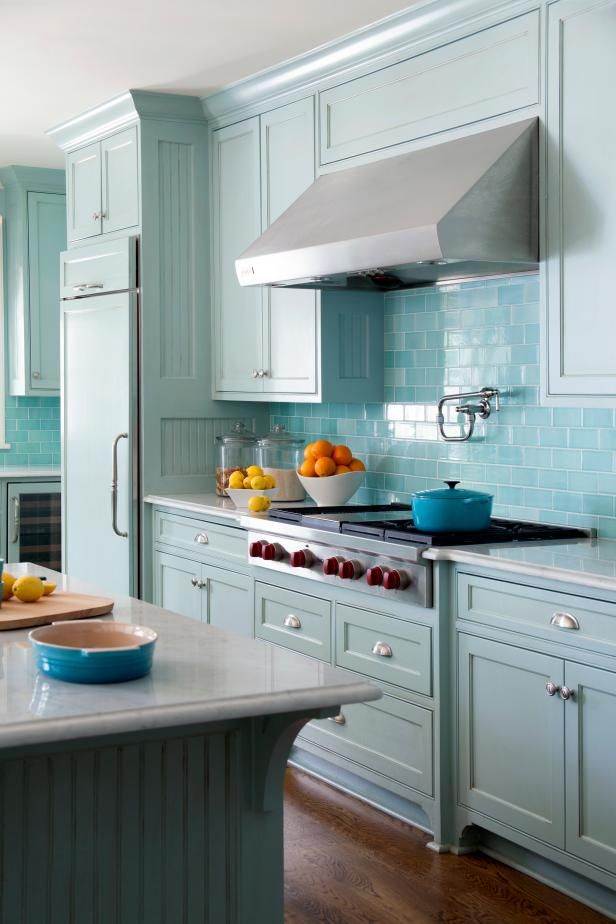 a kitchen with blue cabinets and white counter tops, an island in the middle has fruit on it