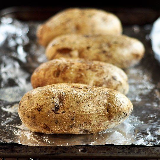 potatoes are lined up on tin foil and ready to be cooked