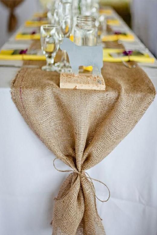 the table is decorated with burlap and glass bottles