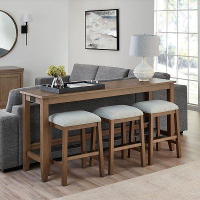 a living room filled with furniture and a large mirror on the wall over a wooden table