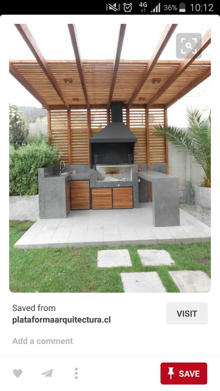 an outdoor kitchen with grill and seating area