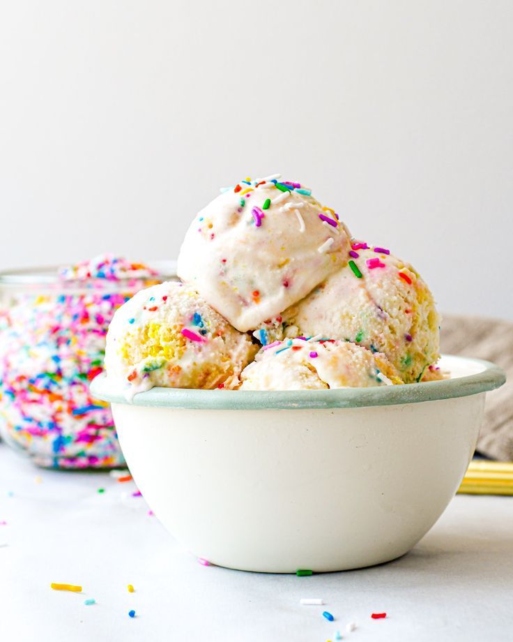 two bowls filled with ice cream and sprinkles on top of a table