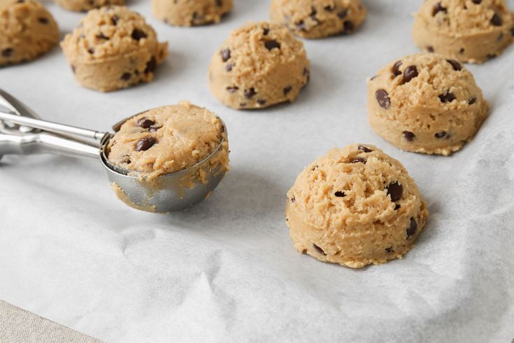 chocolate chip cookies on a baking sheet with a cookie scooper