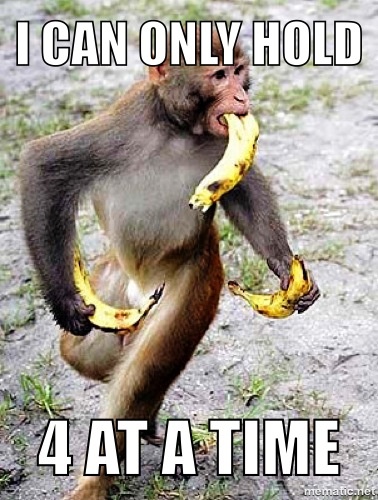 a monkey is holding a banana in its mouth and it's paw on the ground