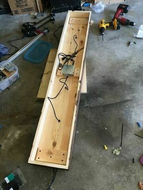 a wooden box with wires connected to it and some tools on the floor next to it