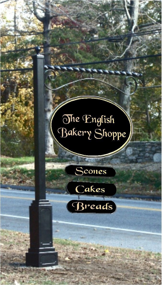 a sign for the english bakery shoppe in front of a road with trees and grass