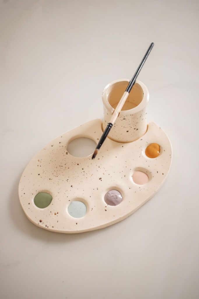 a paint palette and brush on a white tray