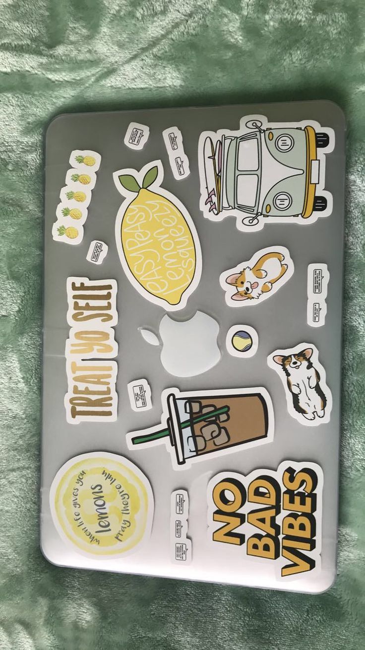 the sticker sheet is on top of a green blanket and there are many different things in it