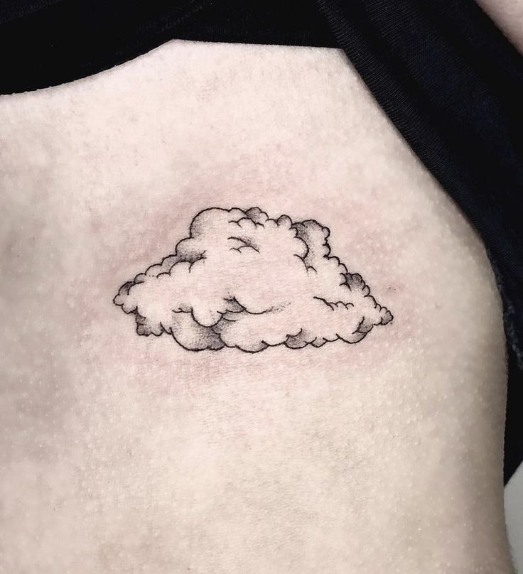 a small black and white cloud tattoo on the back of a woman's stomach