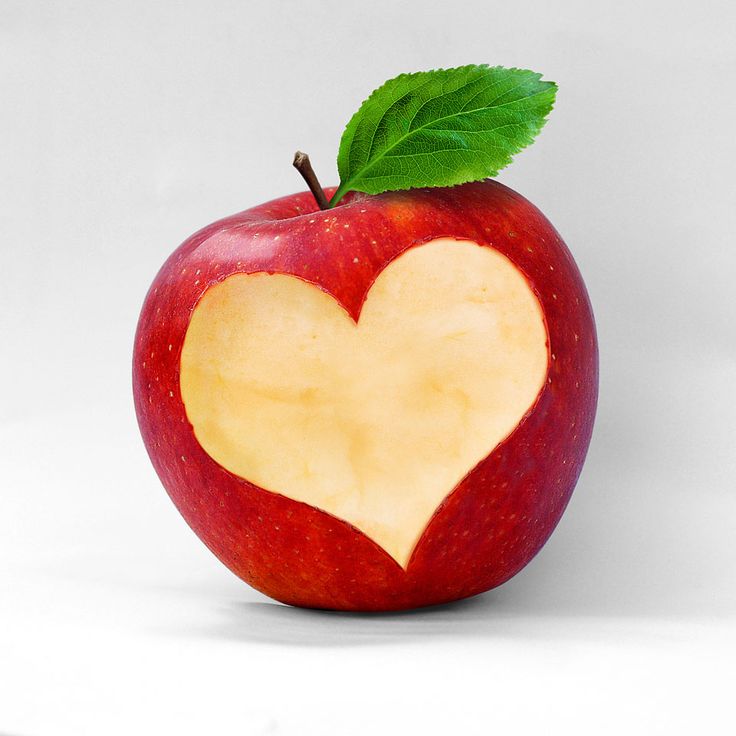 an apple with a heart cut out of it and the words in spanish above it