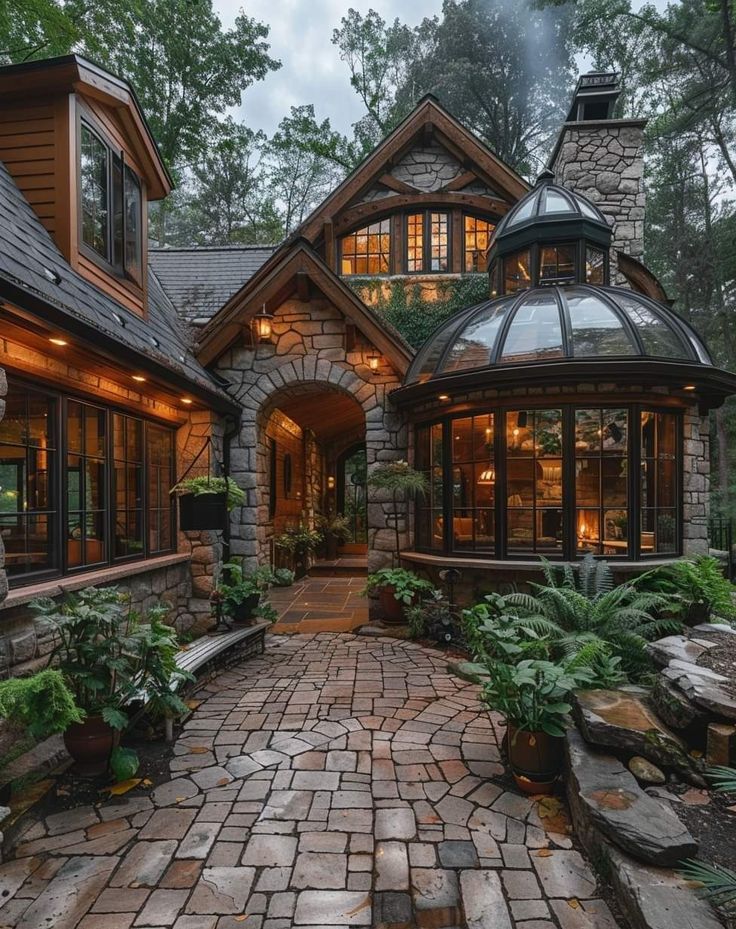 a stone walkway leading to a house with lots of windows