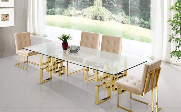 a glass table with gold legs and beige chairs